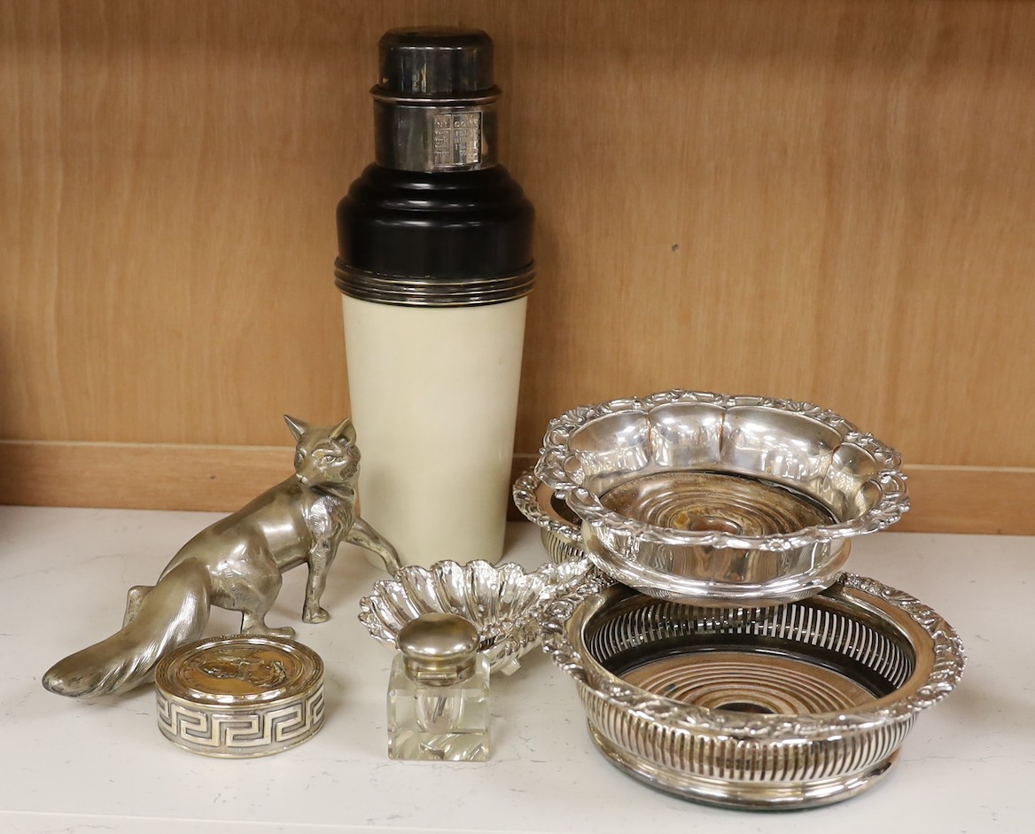 Three silver plated wine coasters, a pair of shell butter dishes, fox, ink well and a cocktail shaker